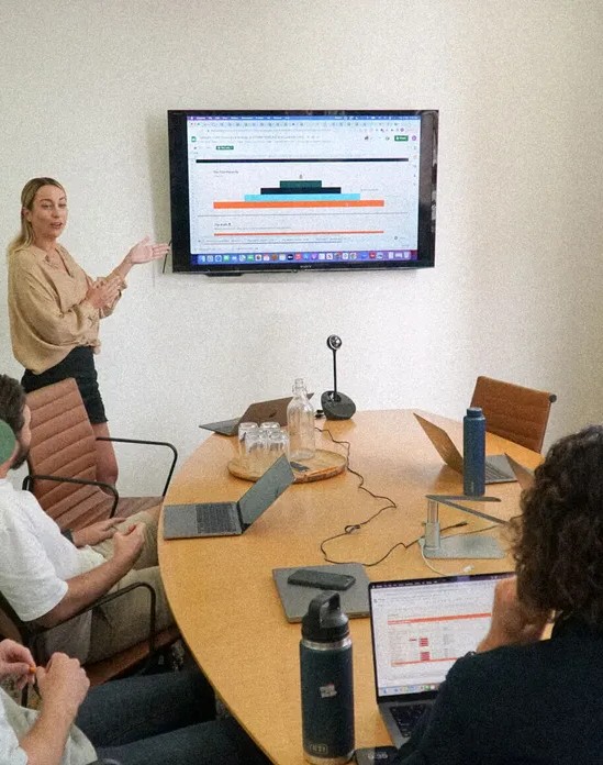 Web Viral Solutions team reviewing campaign performance around a conference table